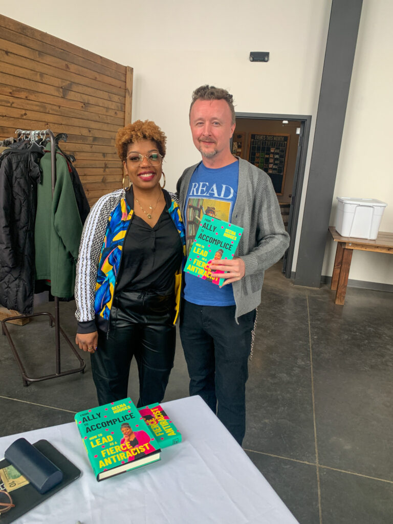 Activist and author Seena Hodges and actor Paul Cram who is holding her book "From Ally to Accomplice"