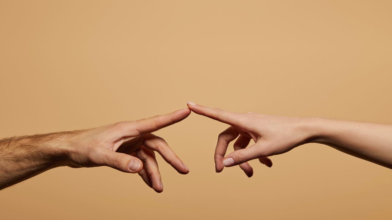 Two people's finger tips touching