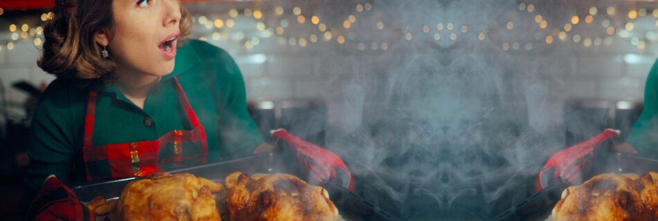 woman in kitchen with burnt holiday meal